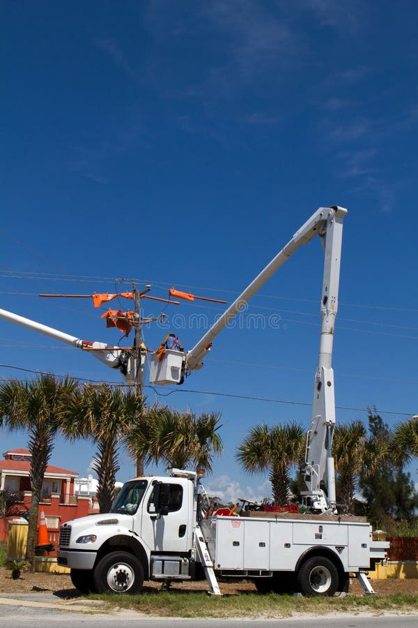 Electrical lineman work on high voltage power lines from the safety of a bucket on a cherry picker truck. Electrical lineman work on high voltage power lines from the safety of a bucket on a cherry picker truck.