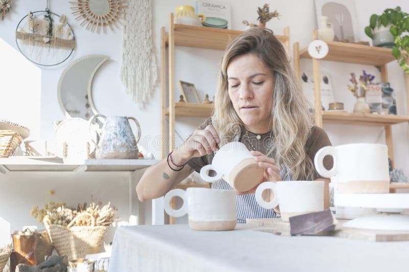 Συλλογή Mug Γυναικών Κεραμολόγων στον πάγκο εργασίας στοκ φωτογραφίες