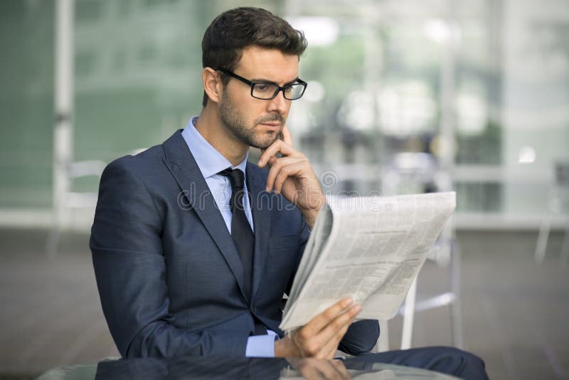 Συνεδρίαση επιχειρησιακών ατόμων στη καφετερία με μια εφημερίδα στοκ εικόνα Συνεδρίαση επιχειρησιακών ατόμων στη καφετερία με μια εφημερίδα στοκ εικόνα