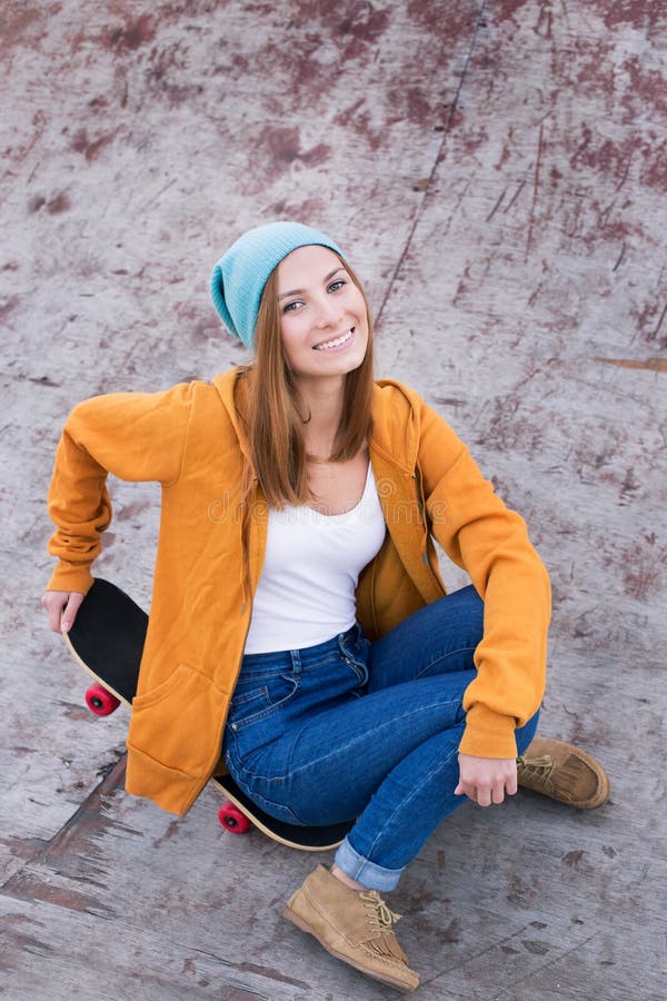Συνεδρίαση σπουδαστών skateboard και χαμόγελο στη κάμερα στοκ φωτογραφία