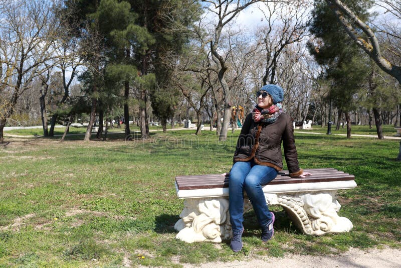 Συνεδρίαση γυναικών στον πάγκο την άνοιξη στοκ φωτογραφίες με δικαίωμα ελεύθερης χρήσης Συνεδρίαση γυναικών στον πάγκο την άνοιξη στοκ φωτογραφίες με δικαίωμα ελεύθερης χρήσης