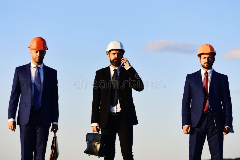 Συνεδρίαση της λαβής εργαζομένων και μηχανικών Αρχιτέκτονες με τα σοβαρά πρόσωπα στοκ εικόνες Συνεδρίαση της λαβής εργαζομένων και μηχανικών Αρχιτέκτονες με τα σοβαρά πρόσωπα στοκ εικόνες