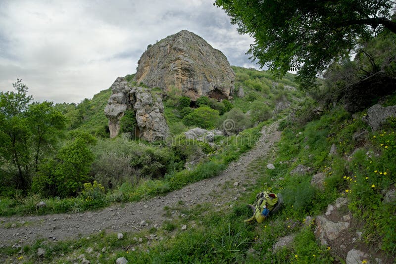 Συννεφιάζω ημέρα στο βράχο Licopeti, τη διάβαση και το πράσινο σακίδιο πλάτης στην επιφύλαξη φύσης Malabotta