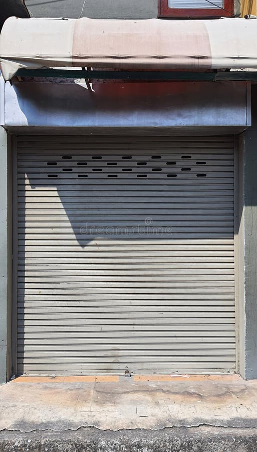Συρόμενη πόρτα χαλύβδινη πόρτα ενός καταστήματος όπου τα παραθυρόφυλλα είναι ασημένια μέταλλα. στοκ φωτογραφία με δικαίωμα ελεύθερης χρήσης