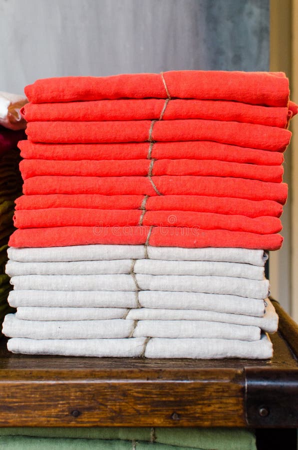 Συσσωρευμένοι linens κόκκινος και άσπρος σε έναν πίνακα στοκ εικόνα με δικαίωμα ελεύθερης χρήσης Συσσωρευμένοι linens κόκκινος και άσπρος σε έναν πίνακα στοκ εικόνα με δικαίωμα ελεύθερης χρήσης