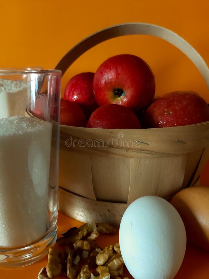 Ingredients for apple pie, flour, sugar, nuts ,eggs and apples are on the kitchen table awaiting cooking. Ingredients for apple pie, flour, sugar, nuts ,eggs and apples are on the kitchen table awaiting cooking.