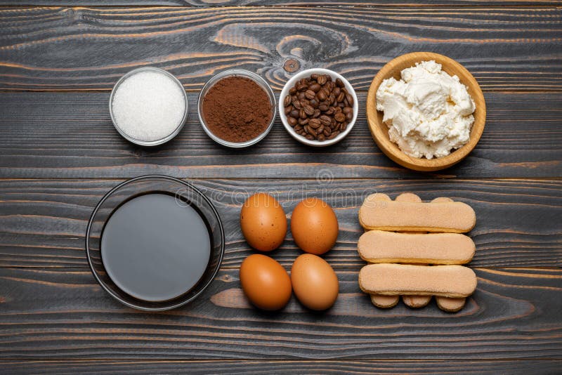 Συστατικά για το tiramisu μαγειρέματος - μπισκότα, mascarpone, τυρί, ζάχαρη, κακάο, καφές και αυγό μπισκότων Savoiardi στοκ φωτογραφία Συστατικά για το tiramisu μαγειρέματος - μπισκότα, mascarpone, τυρί, ζάχαρη, κακάο, καφές και αυγό μπισκότων Savoiardi στοκ φωτογραφία