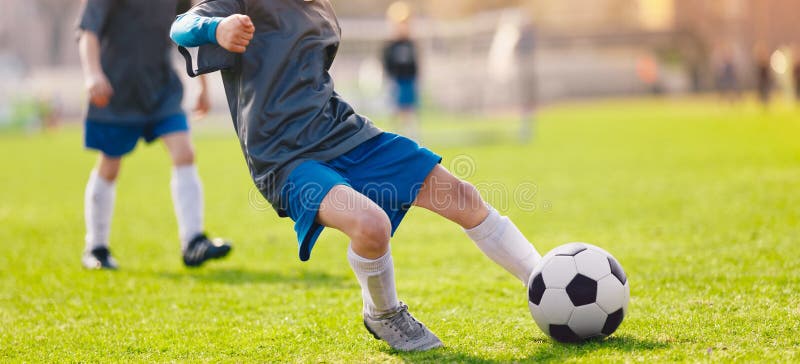 Σφαίρα ποδοσφαίρου λακτίσματος παιδιών Το παιδί κάνει έναν αποτελεσματικό πυροβολισμό ποδοσφαίρου