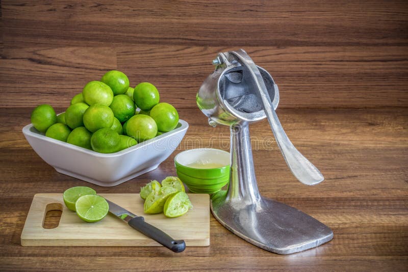 Σωρός του πράσινου λεμονιού με squeezer juicer αργιλίου τα χειρωνακτικά φρούτα στοκ φωτογραφία με δικαίωμα ελεύθερης χρήσης Σωρός του πράσινου λεμονιού με squeezer juicer αργιλίου τα χειρωνακτικά φρούτα στοκ φωτογραφία με δικαίωμα ελεύθερης χρήσης