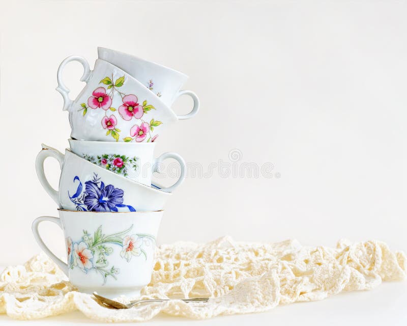 Antique tea cups stacked for high tea on a white background. Antique tea cups stacked for high tea on a white background