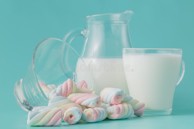 Σωρός χρωματισμένο στριμμένο marshmallow με το ποτήρι του γάλακτος