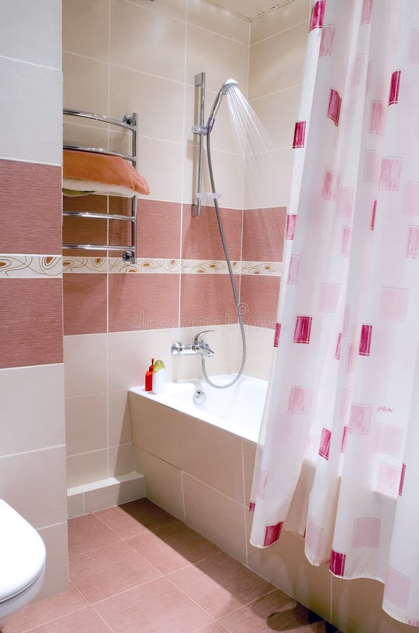 Wide angle view at the small modern bathroom finished with maroon and beige tile. Wide angle view at the small modern bathroom finished with maroon and beige tile