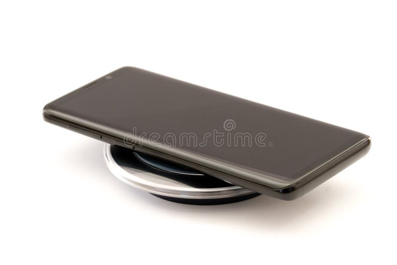 Σύγχρονο μαύρο smartphone που χρεώνει στο ασύρματο μαξιλάρι φορτιστών Απομονωμένος στην άσπρη ανασκόπηση με το ψαλίδισμα του μονο στοκ εικόνα Σύγχρονο μαύρο smartphone που χρεώνει στο ασύρματο μαξιλάρι φορτιστών Απομονωμένος στην άσπρη ανασκόπηση με το ψαλίδισμα του μονο στοκ εικόνα
