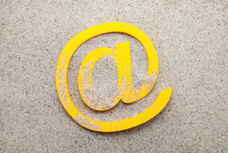 Yellow 3d email symbol in the sand. Yellow 3d email symbol in the sand