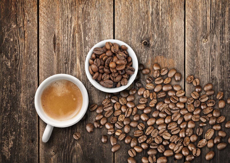 Tho small white coffee cups full of fresh espresso and roasted beans, top view on old wooden table. Tho small white coffee cups full of fresh espresso and roasted beans, top view on old wooden table