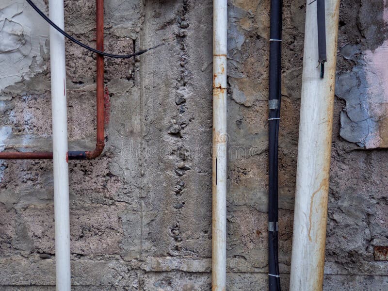 σύρματα και σωλήνες στον τοίχο μέχρι το δρόμο. επαγγελματικές επικοινωνίες. δίκτυο ηλεκτρικής ενέργειας στοκ εικόνες με δικαίωμα ελεύθερης χρήσης