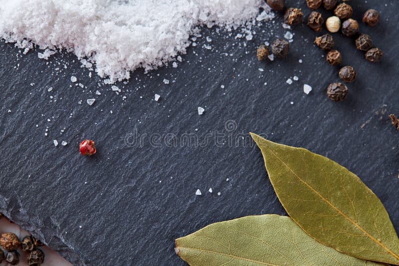 Σύσταση του φύλλου δαφνών κόλπων με peppercorn και του άλατος που απομονώνεται στο σκοτεινό υπόβαθρο, τοπ άποψη, κινηματογράφηση στοκ εικόνες με δικαίωμα ελεύθερης χρήσης Σύσταση του φύλλου δαφνών κόλπων με peppercorn και του άλατος που απομονώνεται στο σκοτεινό υπόβαθρο, τοπ άποψη, κινηματογράφηση στοκ εικόνες με δικαίωμα ελεύθερης χρήσης