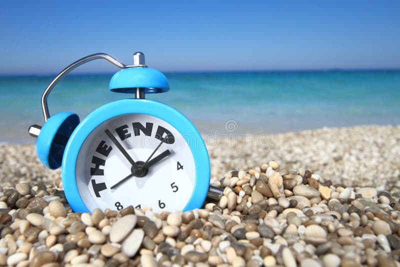 End of summer concept. Alarm clock on the beach. End of summer concept. Alarm clock on the beach