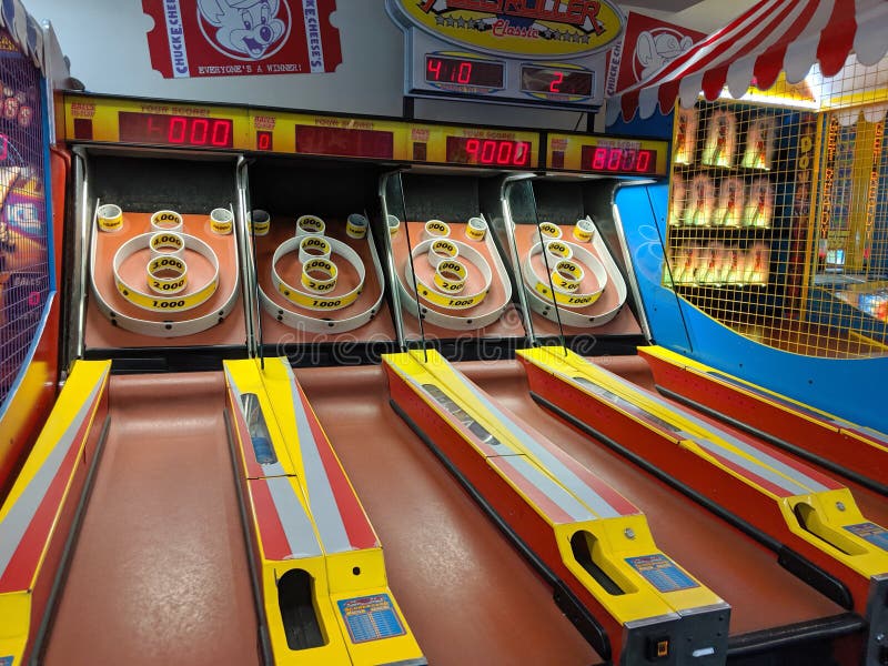 Honolulu - September 15, 2019:  Four Skee-Ball tables for play in arcade at Chuck E. Cheese.   It is played by rolling a ball up an inclined lane and over a &#x22;ball-hop&#x22; hump that jumps the ball into bullseye rings. The object of the game is to collect as many points as possible by having the ball fall into holes in the rings which have progressively increasing point values. Honolulu - September 15, 2019:  Four Skee-Ball tables for play in arcade at Chuck E. Cheese.   It is played by rolling a ball up an inclined lane and over a &#x22;ball-hop&#x22; hump that jumps the ball into bullseye rings. The object of the game is to collect as many points as possible by having the ball fall into holes in the rings which have progressively increasing point values