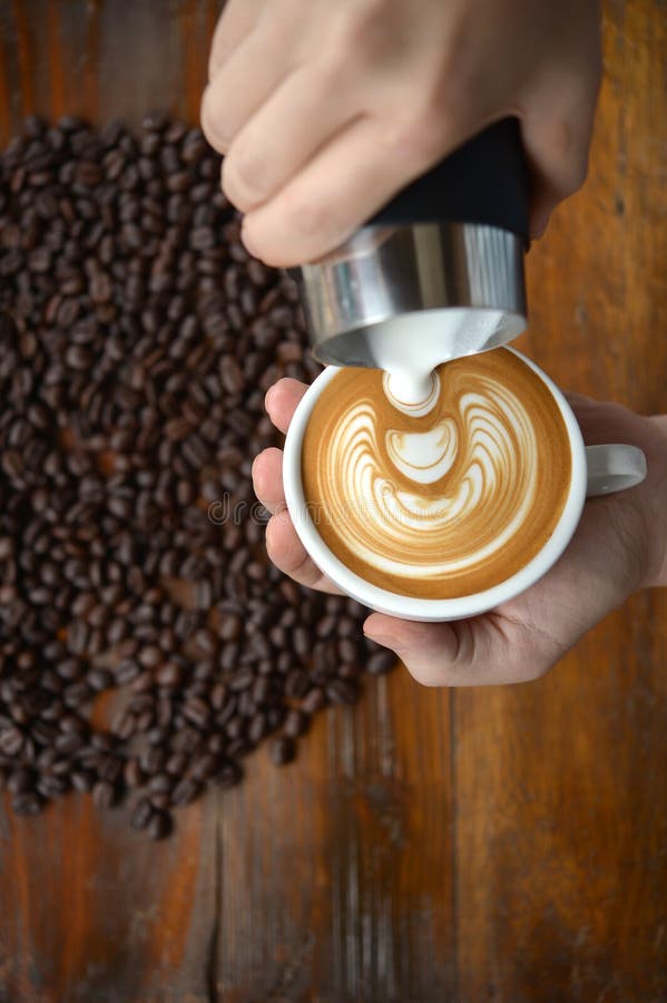 Τέχνη φλιτζανιών του καφέ latte που κάνει από το barista στο παλαιό ξύλινο backgrou στοκ εικόνες