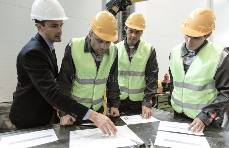 Τα andworkers μηχανικών συζητούν τα έγγραφα στοκ εικόνες Τα andworkers μηχανικών συζητούν τα έγγραφα στοκ εικόνες