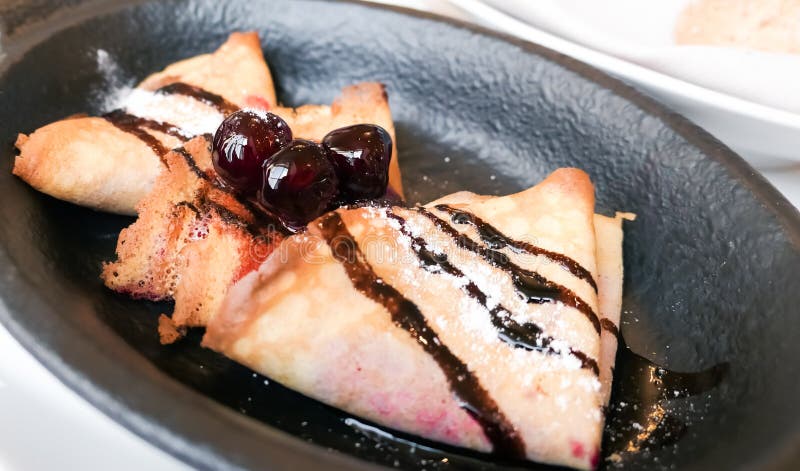 Τα γαλλικά crepes με τη σάλτσα και τα κεράσια σοκολάτας σε έναν reastaurant στο στοκ φωτογραφίες Τα γαλλικά crepes με τη σάλτσα και τα κεράσια σοκολάτας σε έναν reastaurant στο στοκ φωτογραφίες