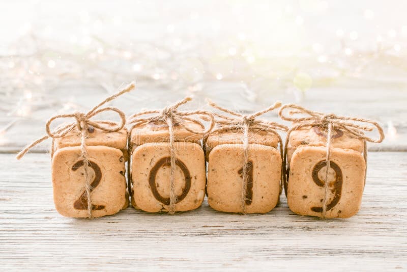Τα εορταστικά ψηφία το 2019 Χριστουγέννων δώρων έκαναν από τα μπισκότα στο άσπρο υπόβαθρο με τα φω'τα και bokeh Εύγευστο γλυκό co στοκ φωτογραφία με δικαίωμα ελεύθερης χρήσης Τα εορταστικά ψηφία το 2019 Χριστουγέννων δώρων έκαναν από τα μπισκότα στο άσπρο υπόβαθρο με τα φω'τα και bokeh Εύγευστο γλυκό co στοκ φωτογραφία με δικαίωμα ελεύθερης χρήσης