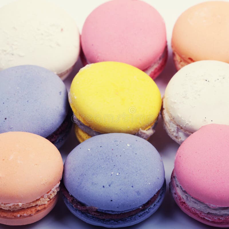 Τα ζωηρόχρωμα γαλλικά μπισκότα macaron κλείνουν επάνω, τετραγωνική εικόνα στοκ εικόνα Τα ζωηρόχρωμα γαλλικά μπισκότα macaron κλείνουν επάνω, τετραγωνική εικόνα στοκ εικόνα