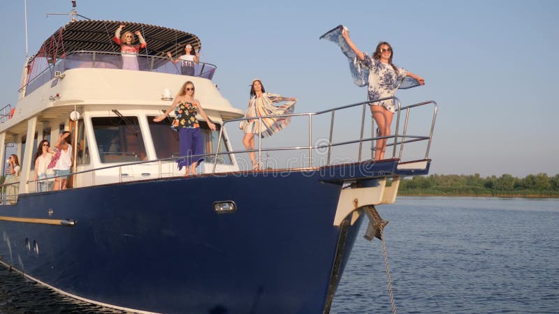Τα θηλυκά οδηγούν στο γιοτ και ο χορός και ο αέρας αναπτύσσουν τα ενδύματα εν πλω στον ποταμό στις διακοπές απόθεμα βίντεο Τα θηλυκά οδηγούν στο γιοτ και ο χορός και ο αέρας αναπτύσσουν τα ενδύματα εν πλω στον ποταμό στις διακοπές απόθεμα βίντεο