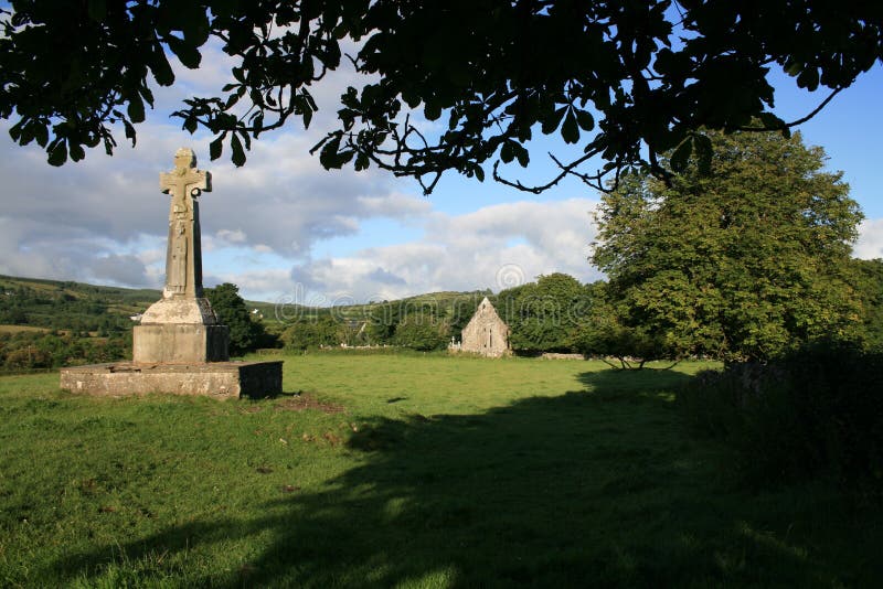 Celtic cross and Dysert o Dea, county Clare, Ireland with church ruins in the background. (Both date to the 12th century). Celtic cross and Dysert o Dea, county Clare, Ireland with church ruins in the background. (Both date to the 12th century)