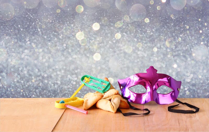 Τα μπισκότα ή hamans τα αυτιά Hamantaschen, noisemaker και η μάσκα για τον εορτασμό Purim (εβραϊκές διακοπές) και ακτινοβολούν υπ στοκ εικόνα με δικαίωμα ελεύθερης χρήσης