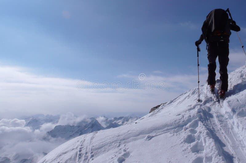 Τα πεζοπορώ και οι αναβάσεις σκιέρ Backcountry σε ένα μακρινό βουνό οξύνουν στην Ελβετία μια όμορφη χειμερινή ημέρα στοκ εικόνες Τα πεζοπορώ και οι αναβάσεις σκιέρ Backcountry σε ένα μακρινό βουνό οξύνουν στην Ελβετία μια όμορφη χειμερινή ημέρα στοκ εικόνες