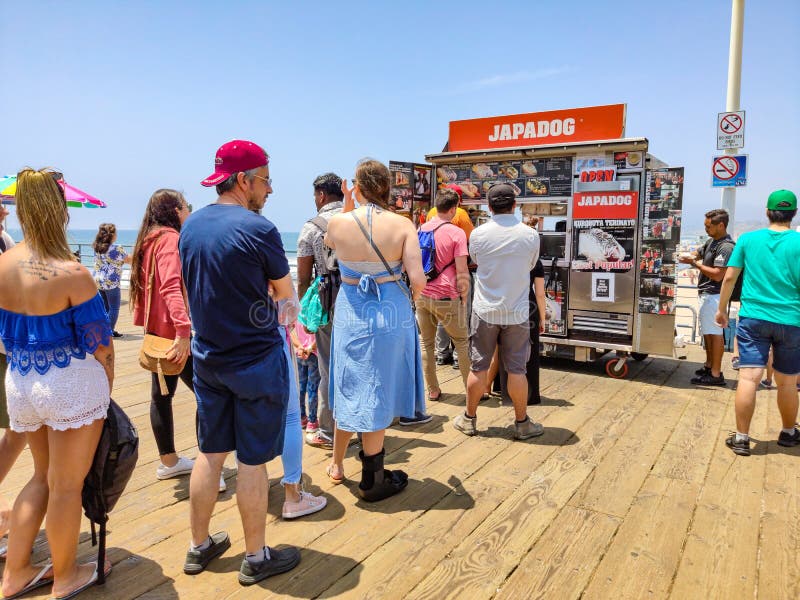 Τα τρόφιμα οδών Japadog, σειρά αναμονής ανθρώπων περιμένουν στην ξύλινη αποβάθρα της Σάντα Μόνικα, παραδοσιακό κατάστημα για τα χ στοκ εικόνα Τα τρόφιμα οδών Japadog, σειρά αναμονής ανθρώπων περιμένουν στην ξύλινη αποβάθρα της Σάντα Μόνικα, παραδοσιακό κατάστημα για τα χ στοκ εικόνα