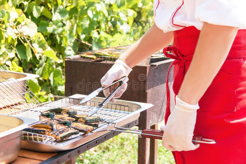 Τα χέρια ενός αρχιμάγειρα μαγειρεύουν τα εύγευστα λαχανικά σε μια σχάρα στοκ φωτογραφίες με δικαίωμα ελεύθερης χρήσης