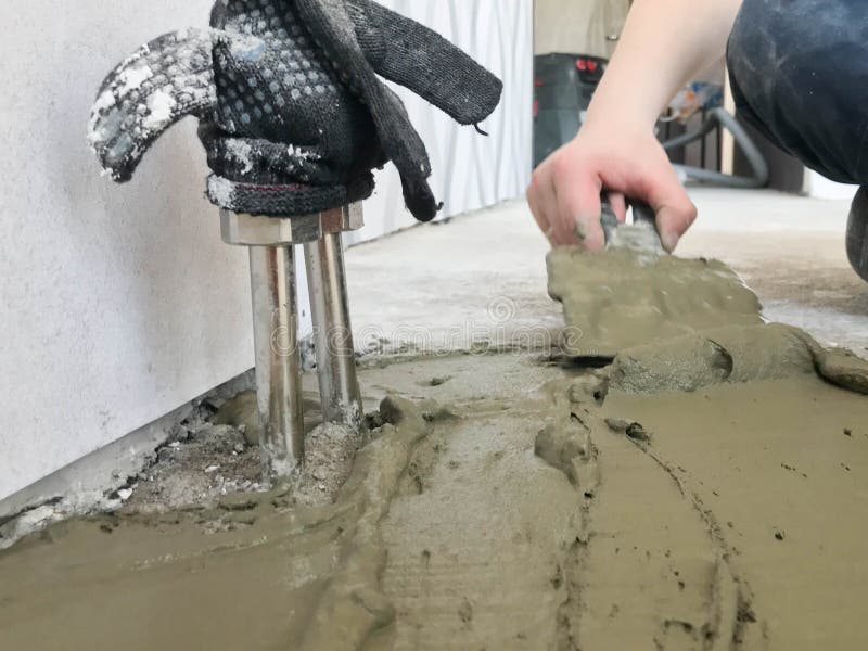 Τα χέρια οικοδόμων με spatula μετάλλων επικονιάζουν τον τοίχο, χύνουν το ασβεστοκονίαμα κατεβατών, κόλλα κεραμιδιών, τσιμέντο για στοκ εικόνες με δικαίωμα ελεύθερης χρήσης Τα χέρια οικοδόμων με spatula μετάλλων επικονιάζουν τον τοίχο, χύνουν το ασβεστοκονίαμα κατεβατών, κόλλα κεραμιδιών, τσιμέντο για στοκ εικόνες με δικαίωμα ελεύθερης χρήσης