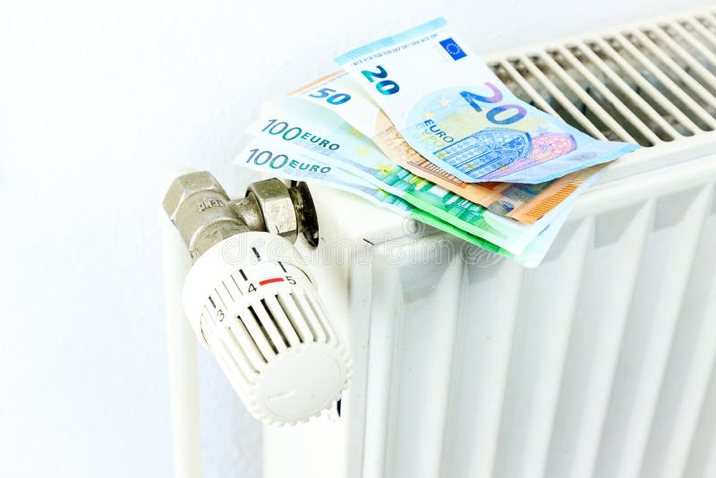 Τα χρήματα σε ένα θερμαντικό σώμα συμβολίζουν τις ακριβές δαπάνες θέρμανσης στοκ φωτογραφία με δικαίωμα ελεύθερης χρήσης
