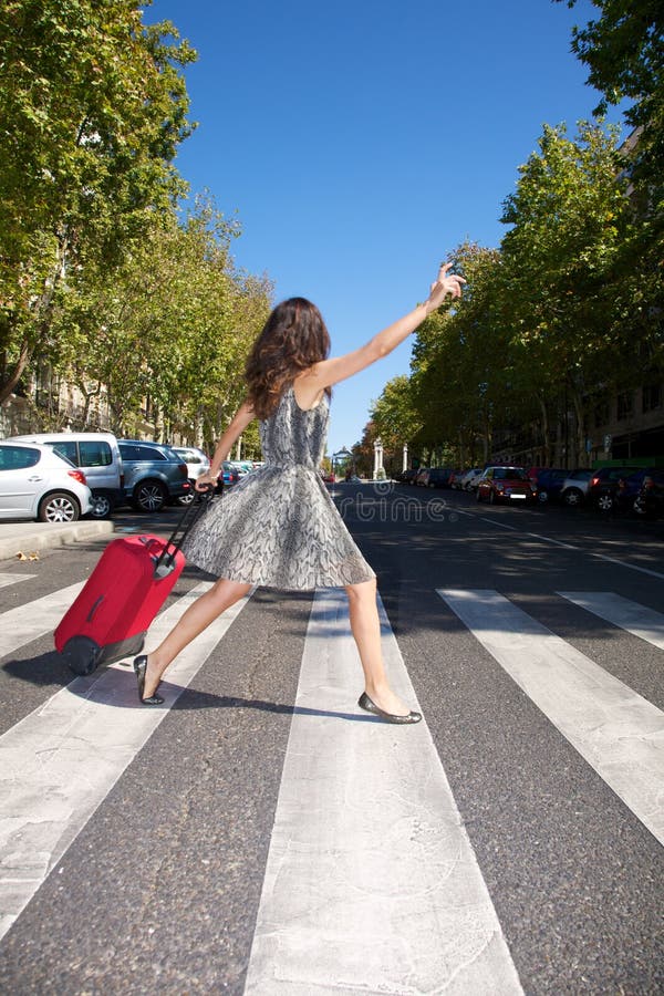 Brunette woman with red suitcase walking in Madrid city Spain. Brunette woman with red suitcase walking in Madrid city Spain