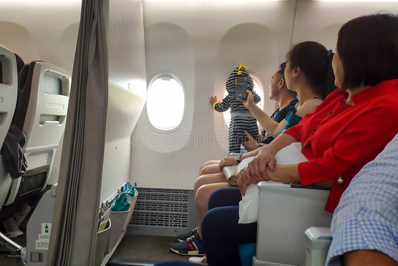 Ταϊλάνδη, Phuket - 27 Φεβρουαρίου 2019: Νέα ασιατική οικογένεια στο αεροπλάνο με ένα μικρό παιδί μωρών νηπίων που φαίνεται έξω το στοκ εικόνες με δικαίωμα ελεύθερης χρήσης Ταϊλάνδη, Phuket - 27 Φεβρουαρίου 2019: Νέα ασιατική οικογένεια στο αεροπλάνο με ένα μικρό παιδί μωρών νηπίων που φαίνεται έξω το στοκ εικόνες με δικαίωμα ελεύθερης χρήσης