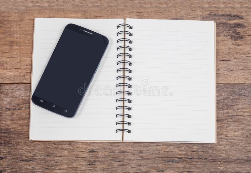Τηλέφωνο Obile και σημείωση βιβλίων εκλεκτής ποιότητας σε ξύλινο στοκ φωτογραφία με δικαίωμα ελεύθερης χρήσης