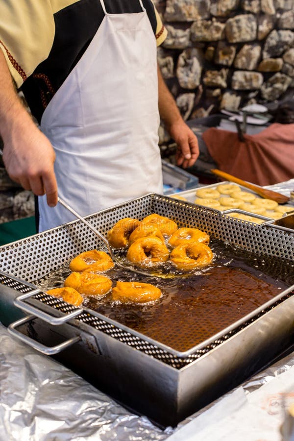 Τηγάνισμα των σπιτικών και εύγευστων donuts στο φρέσκο ελαιόλαδο Χαρακτηριστικά ισπανικά donuts στοκ φωτογραφία με δικαίωμα ελεύθερης χρήσης Τηγάνισμα των σπιτικών και εύγευστων donuts στο φρέσκο ελαιόλαδο Χαρακτηριστικά ισπανικά donuts στοκ φωτογραφία με δικαίωμα ελεύθερης χρήσης