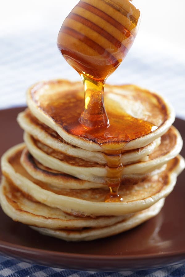 Stack of pancakes with pouring honey closeup. Stack of pancakes with pouring honey closeup