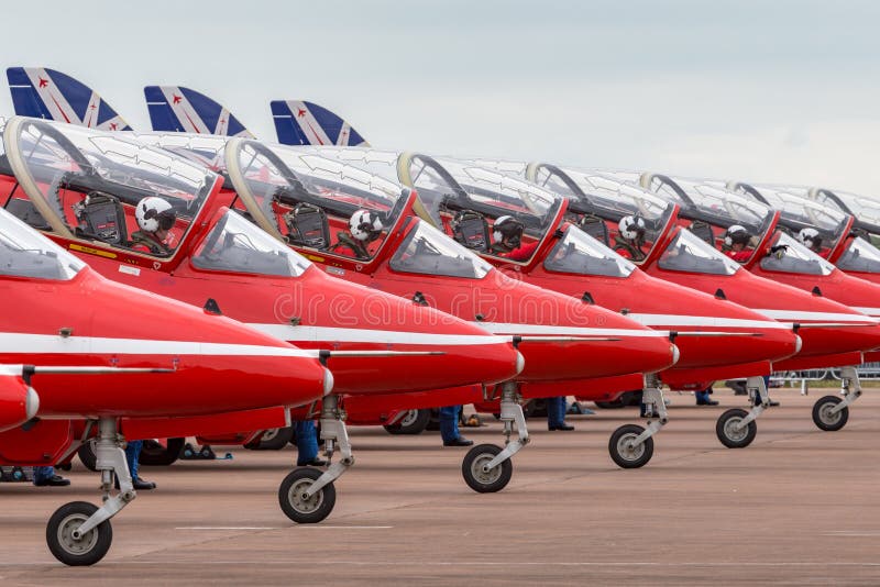 RAF Fairford, Gloucestershire, UK - July 12, 2014: Royal Air Force RAF Red Arrows formation aerobatic display team British Aerospace Hawk T.1 Jet trainer aircraft prepare for takeoff. RAF Fairford, Gloucestershire, UK - July 12, 2014: Royal Air Force RAF Red Arrows formation aerobatic display team British Aerospace Hawk T.1 Jet trainer aircraft prepare for takeoff.