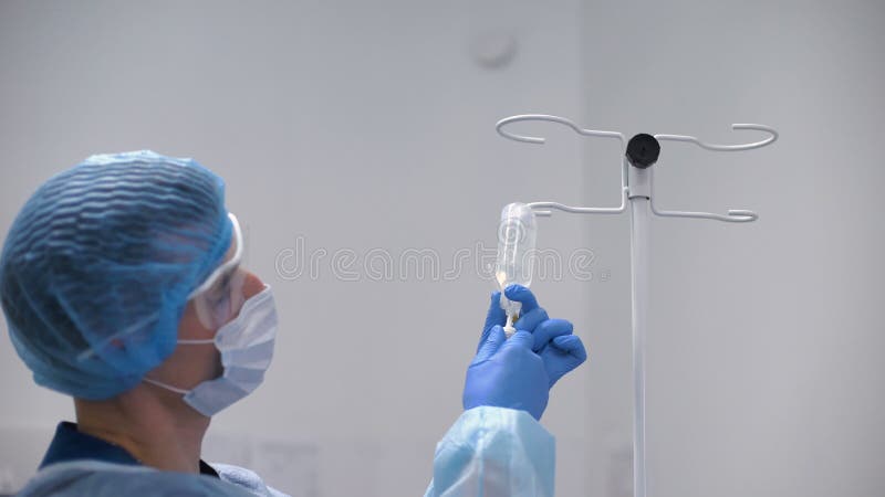 Το anesthesiologist γιατρών νεαρών άνδρων στην εργασία έντυσε στην εσθήτα, τη μάσκα και το καπέλο