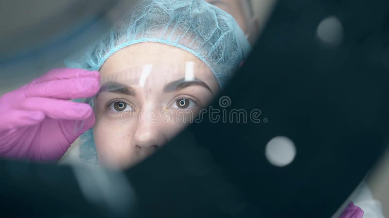 Το Cosmetologist βάζει brow τον κυβερνήτη στο πρόσωπο πελατών με τη δερματοστιξία