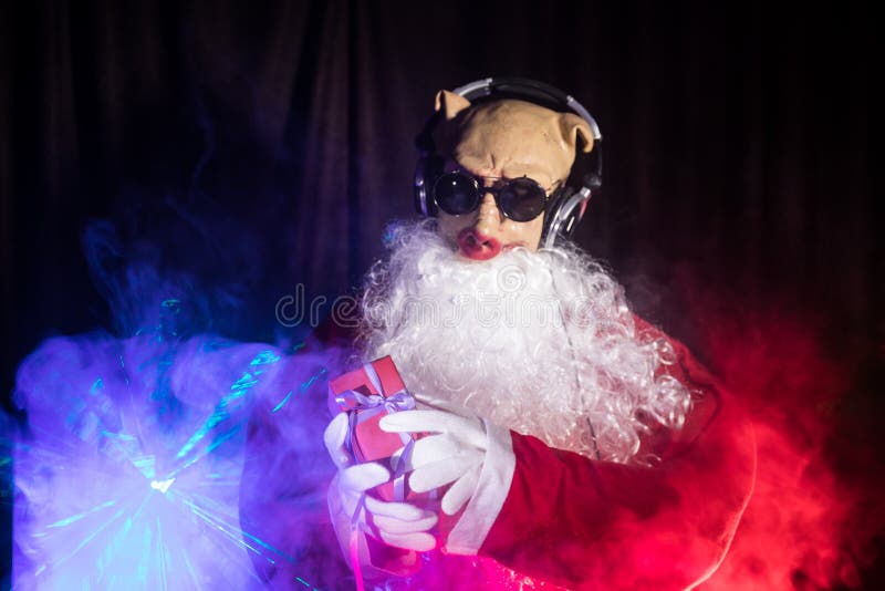 Το DJ Άγιος Βασίλης στα Χριστούγεννα με τα γυαλιά και το χιόνι αναμιγνύουν στο γεγονός Παραμονής Πρωτοχρονιάς στις ακτίνες του φω στοκ φωτογραφίες με δικαίωμα ελεύθερης χρήσης Το DJ Άγιος Βασίλης στα Χριστούγεννα με τα γυαλιά και το χιόνι αναμιγνύουν στο γεγονός Παραμονής Πρωτοχρονιάς στις ακτίνες του φω στοκ φωτογραφίες με δικαίωμα ελεύθερης χρήσης