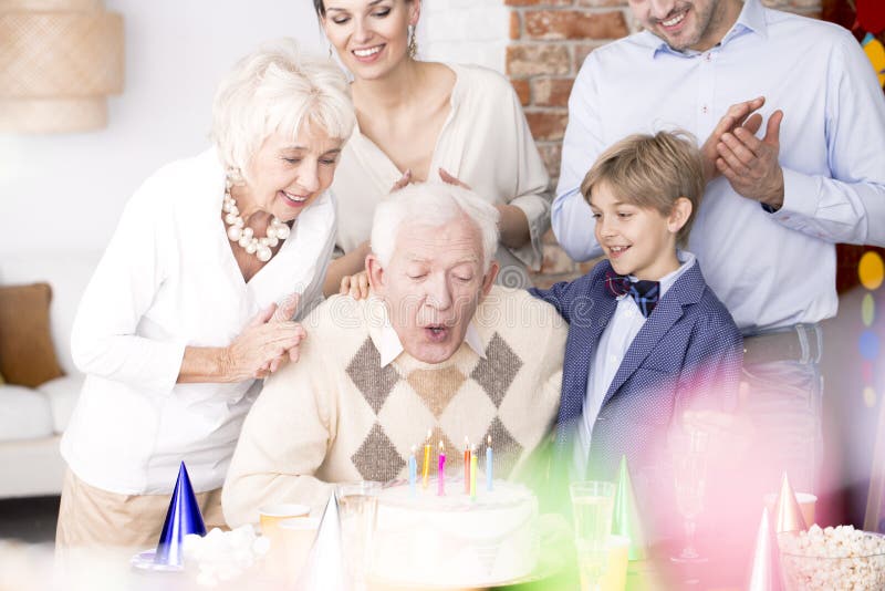 Το Grandpa που εκρήγνυται σημαδεύει στο κέικ γενεθλίων στοκ εικόνα Το Grandpa που εκρήγνυται σημαδεύει στο κέικ γενεθλίων στοκ εικόνα