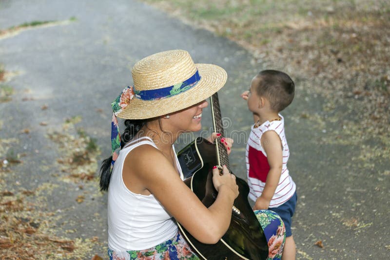 Το Mom διασκεδάζει το γιο της παίζοντας την κιθάρα στοκ εικόνες με δικαίωμα ελεύθερης χρήσης Το Mom διασκεδάζει το γιο της παίζοντας την κιθάρα στοκ εικόνες με δικαίωμα ελεύθερης χρήσης