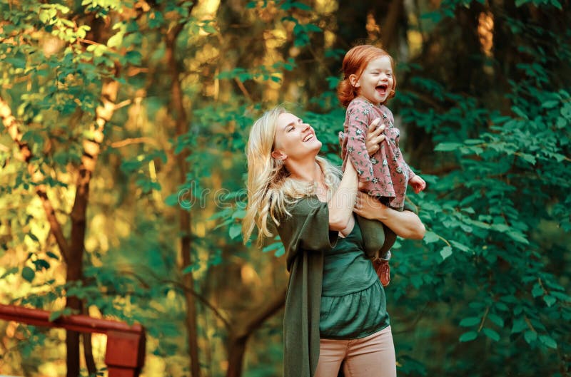 Το Mom και η κοκκινομάλλης κόρη κάθονται και χαμογελούν στο ηλιοβασίλεμα μέσα στοκ φωτογραφία με δικαίωμα ελεύθερης χρήσης