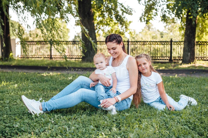 Το Mom και οι κόρες της περπατούν στο θερινό πάρκο στοκ εικόνες Το Mom και οι κόρες της περπατούν στο θερινό πάρκο στοκ εικόνες