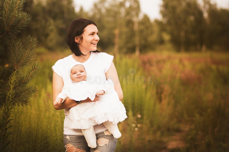 Το Mom κρατά το νεογέννητο μωρό στο πάρκο το καλοκαίρι στοκ εικόνα